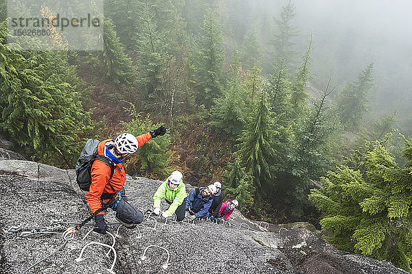 Eine Gruppe von Leuten genießt eine Via Ferrata an einem regnerischen Herbsttag in Squamish  British Columbia.