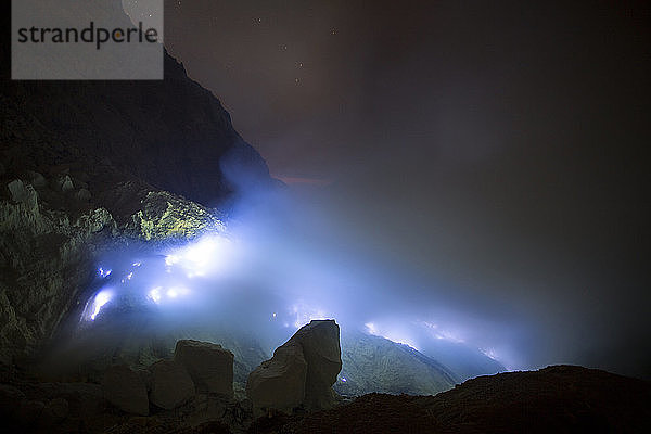 Blaue Flammen aus geschmolzenem Schwefel brennen in der Mine im Krater des Vulkans Kawah Ijen  Banyuwangi  Java  Indonesien