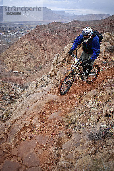 Erfahrene Fahrer fahren eine Downhill-Mountainbike-Strecke hinunter  die in die Stadt Moab  Utah  führt.