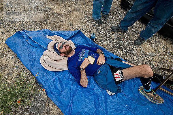 Ein Teilnehmer liegt während des Salt Flats 100 in Bonneville  Utah  erschöpft auf einer Plane.