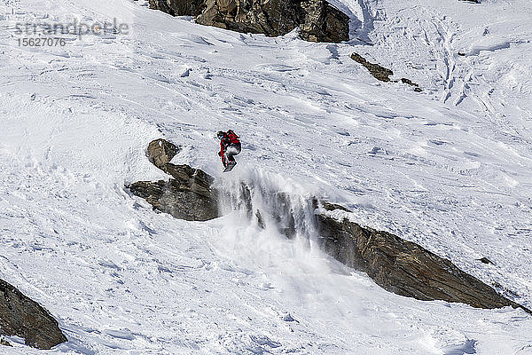 Snowboarder springt von einer Klippe in Val Thorens  Frankreich