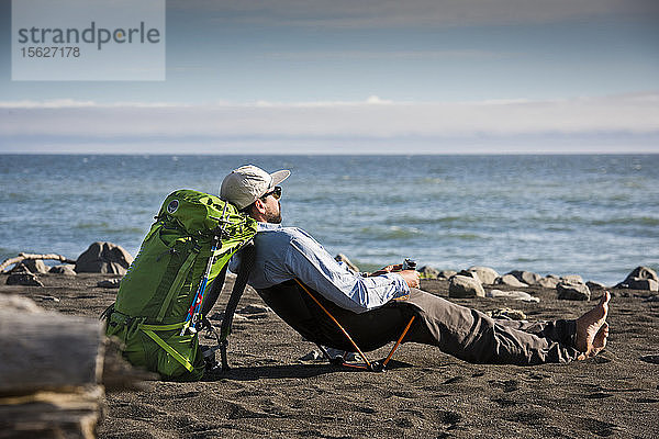 Mann entspannt sich beim Camping an der Lost Coast am Meer