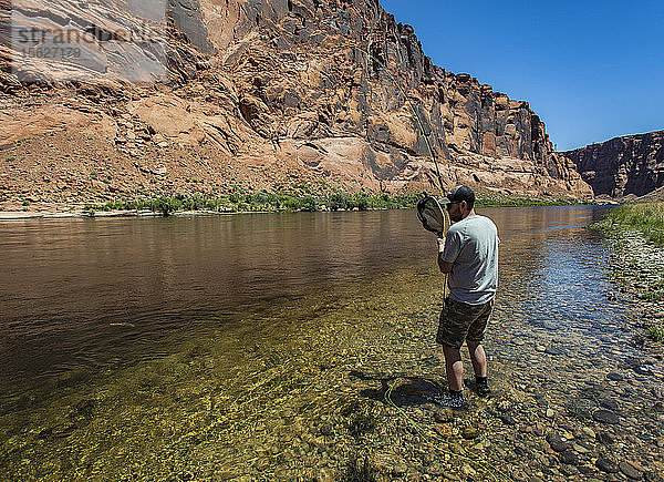 Ein Mann fängt einen Fisch im Colorado River im Grand Canyon