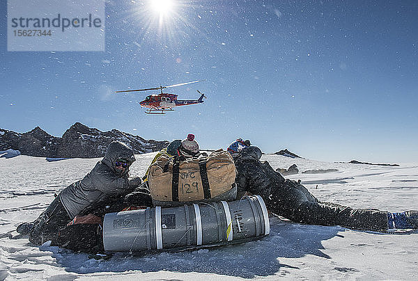 Schutz vor dem Rotorstrahl eines Bell 212-Hubschraubers  nachdem er in 11.000 Fuß Höhe an den Hängen des Mount Erebus in der Antarktis abgesetzt wurde.