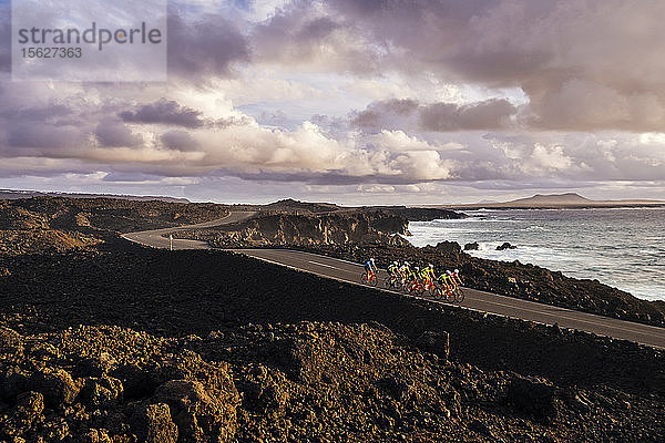 Gruppe von Radfahrern auf der Küstenstraße  Timanfaya-Nationalpark  Lanzarote  Kanarische Inseln  Spanien