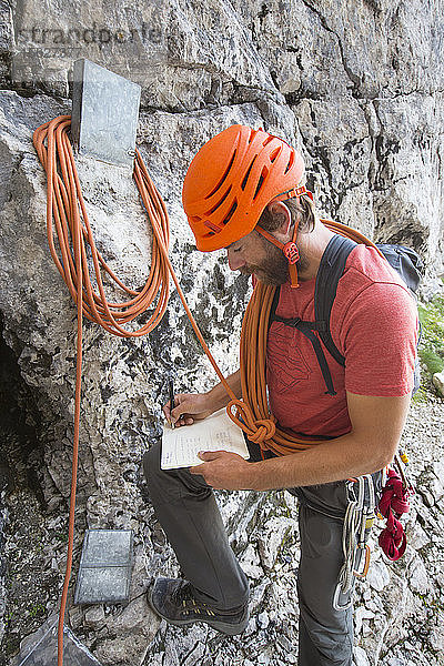 Ein Bergführer trägt seinen Namen in das Gipfelbuch der berühmten Nordwand des Triglav  des höchsten Gipfels Sloweniens  ein
