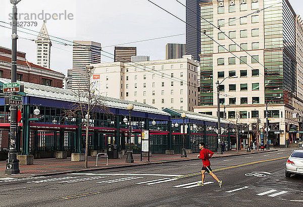 Männlicher Läufer beim Überqueren der Straße in der Innenstadt von Seattle  Washington State  USA