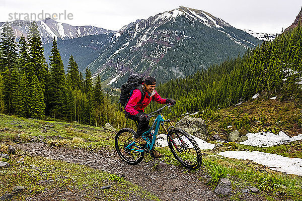 Mountainbikerin in malerischer Landschaft fährt auf dem Ice Lakes Trail im Regen  USA