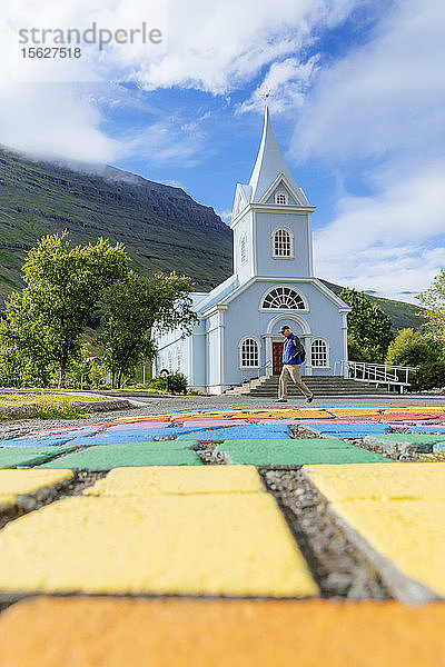 Die Hauptstraße von Seydisfjordur ist in den leuchtenden Farben des Regenbogens gestrichen  Island