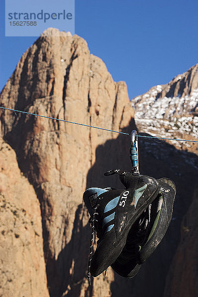 Kletterschuhe zum Trocknen nach einem Regentag  mit den Bergen im Hintergrund Taghia  während einer Kletterexpedition