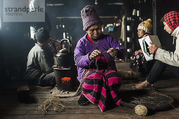 Ältere Frau mit Strickmütze beim Stricken in einem kleinen ländlichen Haus  Myanmar  Shan  Myanmar