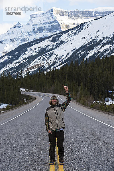 Snowboarder  der in der Mitte der Straße in Kanada steht