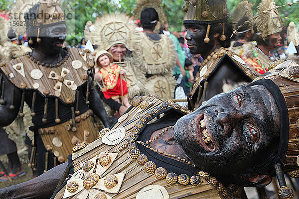 Lustiger alter Mann vor einer Gruppe von Menschen in Stammeskostümen beim Ati Atihan Festival  Kalibo  Aklan  Panay Island  Philippinen