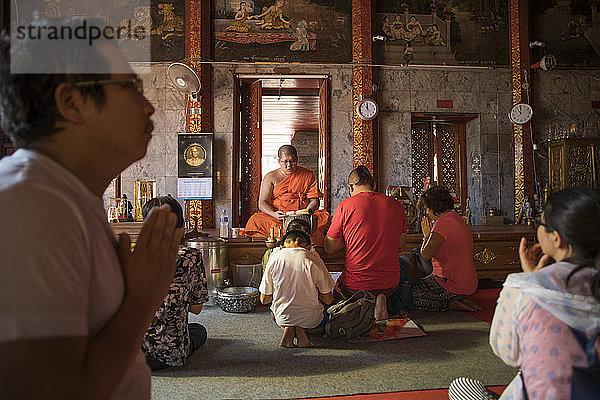 Buddhistischer Mönch segnet Familie im Wat Phra That Doi Suthep  Chiang Mai  Thailand