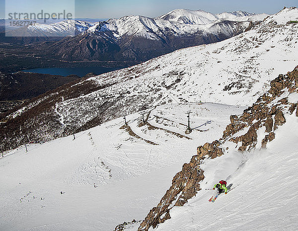 Ein Skifahrer macht eine Wende durch einige Felsen am Cerro Catedral in Argentinien