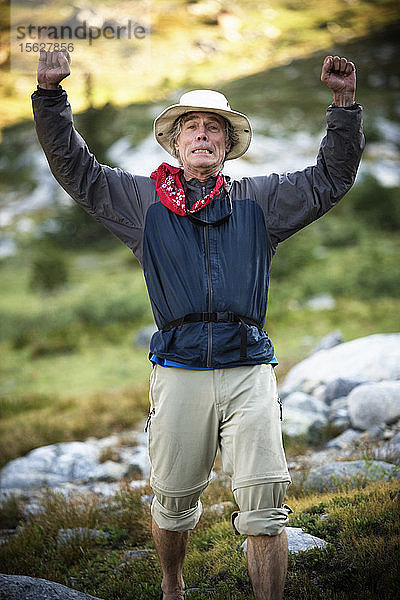 Ein erwachsener männlicher Wanderer mit erhobenen Armen in der Ansel Adams Wilderness  Sierra Nevada Mountains  Kalifornien  USA.