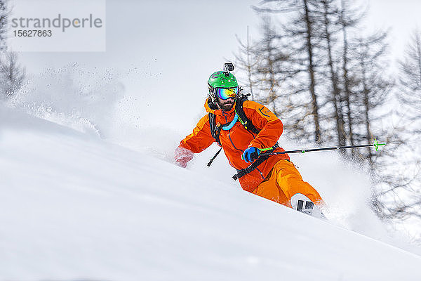 Skifahrer Paolo Marazzi spielt mit seinen Telemark-Skiern in einem schönen Wald in den westitalienischen Alpen