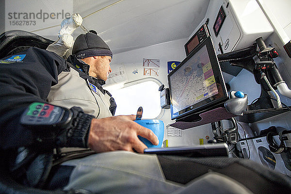 Segler beim Frühstück in der Rettungsstation und der Navigationsstation an Bord eines Trimarans  Atlantik  Bretagne  Frankreich