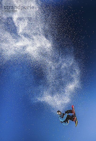 Ein Snowboarder springt auf dem Dachstein-Gletscher in Österreich in die Luft und hinterlässt eine Schneespur.