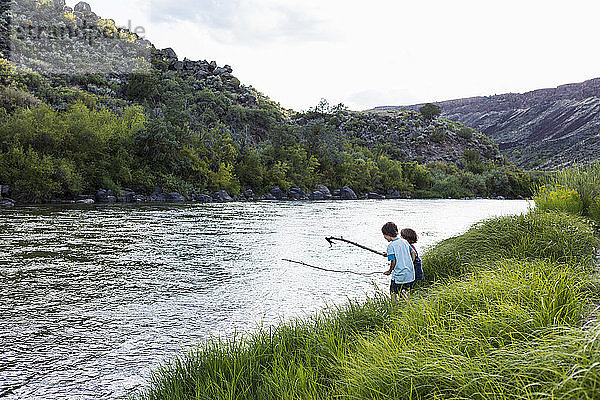 2 Jungen spielen am Ufer des Rio Grande  Pilar  NM.