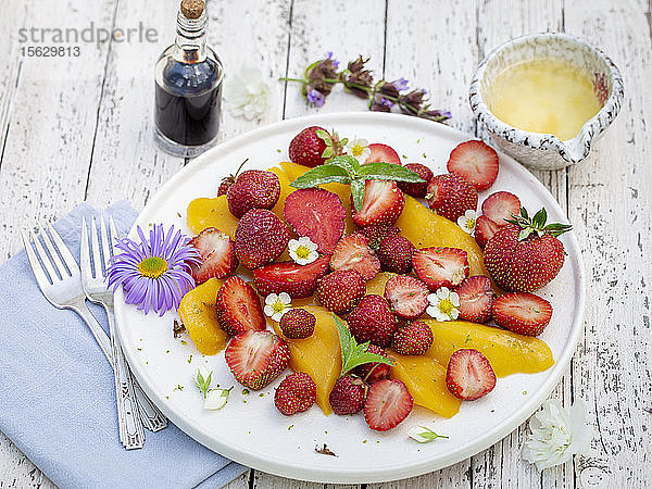 Mango-Erdbeer-Salat auf rustikalem Tisch