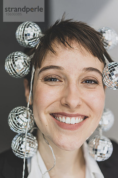 Porträt einer glücklichen jungen Geschäftsfrau mit Spiegelkugeln