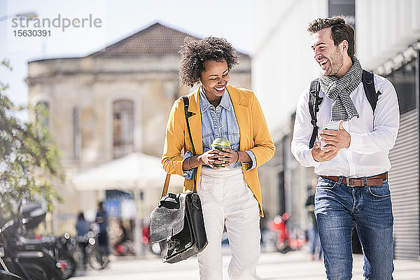Glückliches junges Paar mit Smartphone in der Stadt