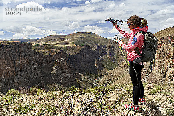 Frau bereitet sich auf Drohnenflug in den Bergen vor  Maletsunyane Falls  Lesotho