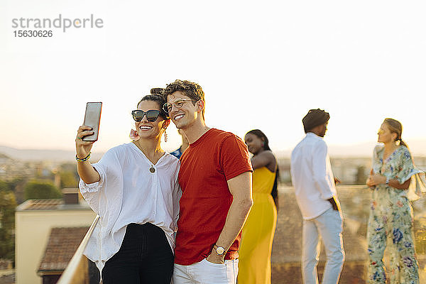 Junge Frau und Mann beim abendlichen Selfie auf einer Party