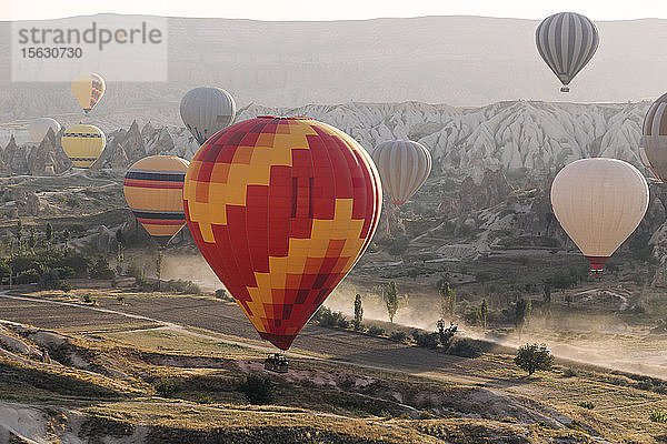 Mehrfarbige Heißluftballons überfliegen bei Sonnenuntergang den Goreme-Nationalpark  Kappadokien  Türkei