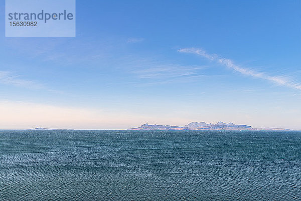 Szenische Ansicht des Meeres mit den Inseln Eigg  Rum und Muck im Hintergrund vor dem Himmel  Lochailort  Schottland  UK