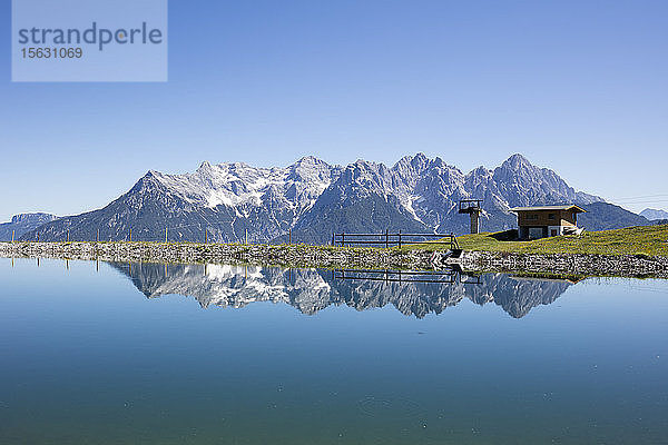 Aussicht auf den ruhigen See und die Loferer Steinberge bei strahlend blauem Himmel  KitzbÃ¼hel  Tirol  Österreich