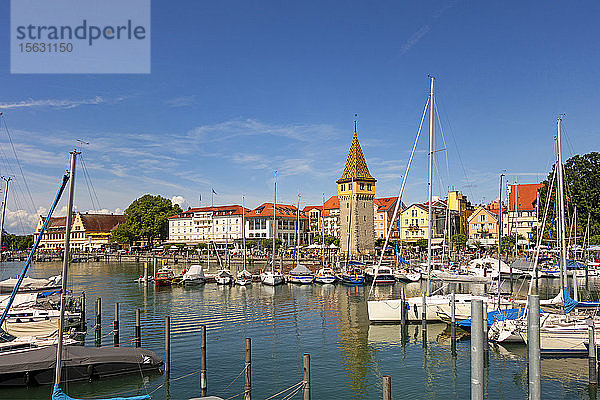 Am Hafen vertäute Boote mit Gebäuden im Hintergrund vor blauem Himmel  Lindau  Deutschland