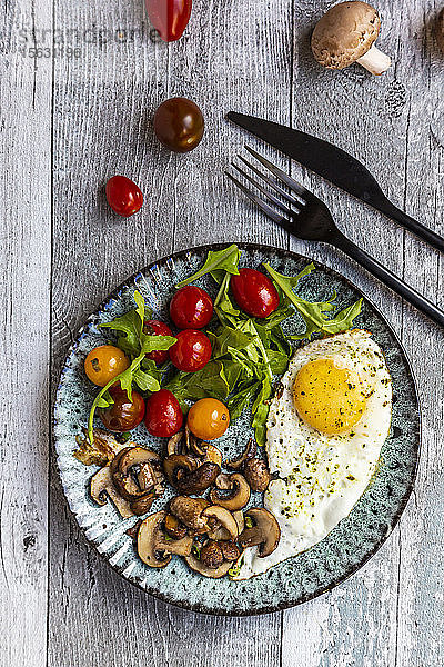 Low-Carb-Frühstück mit Spiegelei  Champignons  Rucola und Tomaten