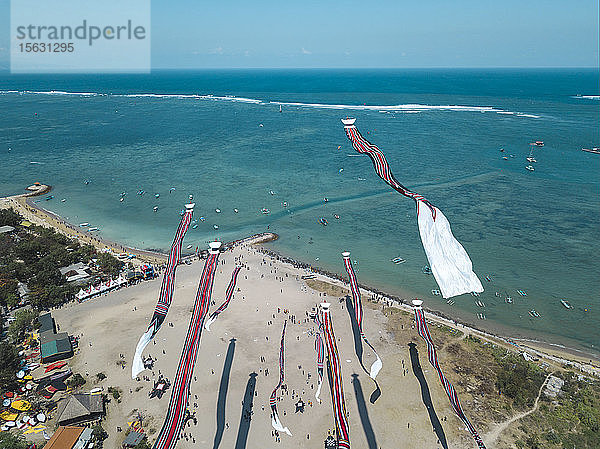 Luftaufnahme von Drachen  die am Strand gegen den blauen Himmel während des Festivals in Bali  Indonesien  fliegen