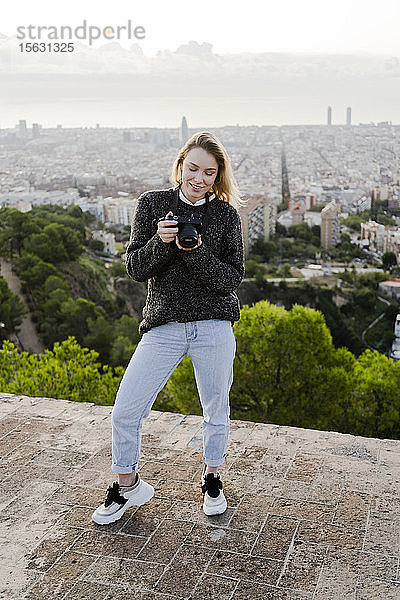 Junge Frau mit Kamera über der Stadt bei Sonnenaufgang  Barcelona  Spanien