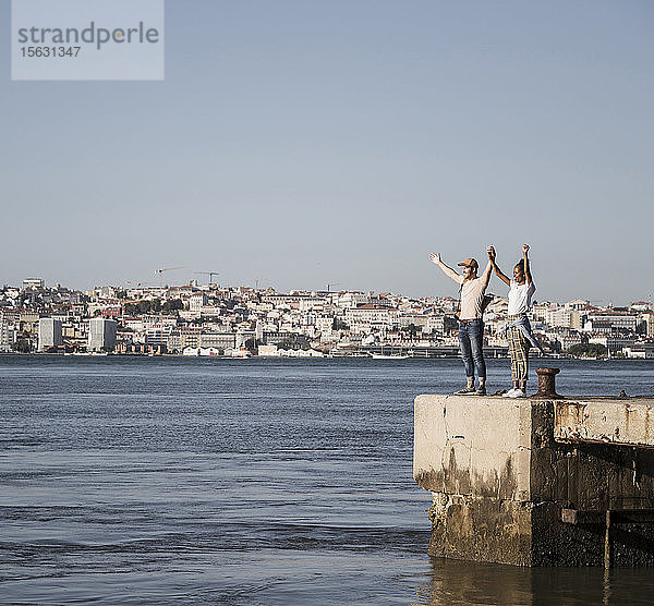 Glückliches junges Paar steht am Pier am Wasser  Lissabon  Portugal