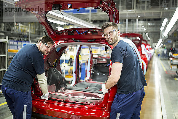 Zwei Kollegen arbeiten in einer modernen Autofabrik
