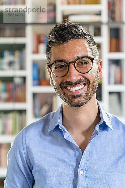 Porträt eines lachenden jungen Mannes mit Brille