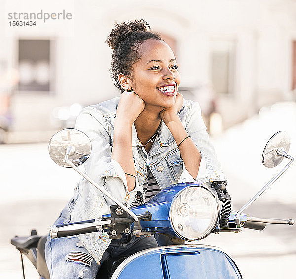 Glückliche junge Frau mit Motorroller in der Stadt  Lissabon  Portugal