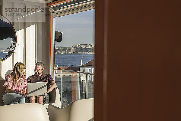 Mann und Frau mit Laptop auf einer sonnigen Terrasse  Lissabon  Portugal