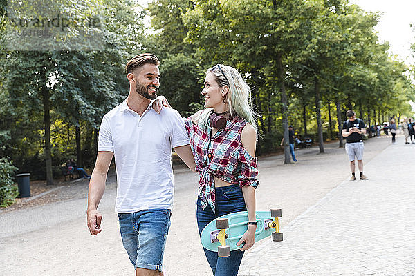 Glückliches junges Paar beim Spaziergang in einem Park