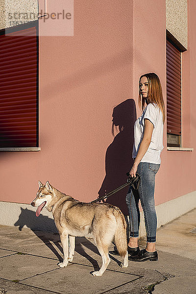 Porträt einer jungen Frau  die abends mit ihrem Hund Gassi geht
