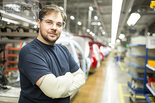 Porträt eines selbstbewussten Arbeiters in einer modernen Autofabrik
