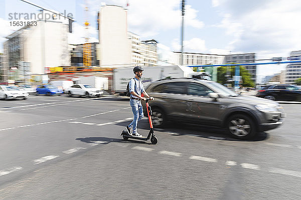 Geschäftsmann mit E-Scooter auf der Straße in der Stadt  Berlin  Deutschland