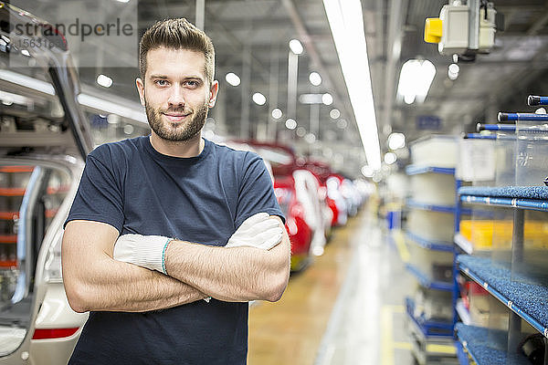 Porträt eines selbstbewussten Arbeiters in einer modernen Autofabrik