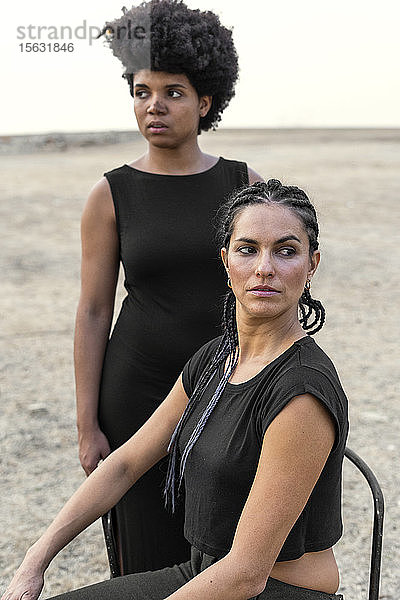 Porträt von zwei schwarz gekleideten Frauen in trostloser Landschaft