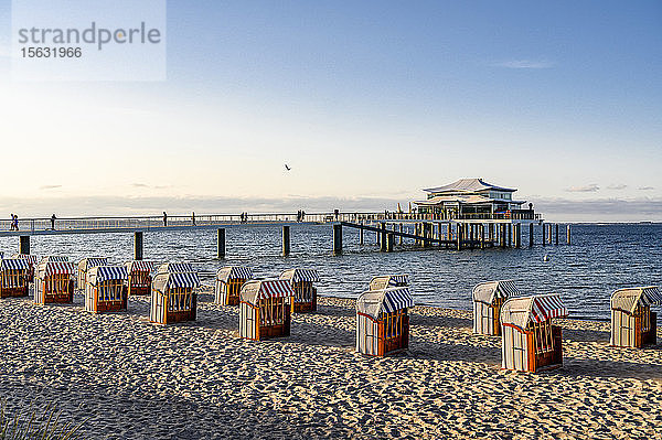 Deutschland  Schleswig-Holstein  Timmendorf  Strandkorb Strandkörbe am sandigen Küstenstrand mit Pier im Hintergrund
