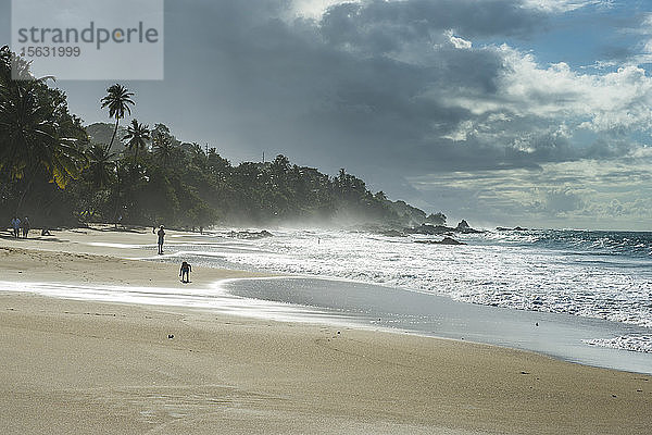 Szenische Ansicht der Wellen  die an der Küste gegen den bewölkten Himmel plätschern  Trinidad und Tobago  Karibik