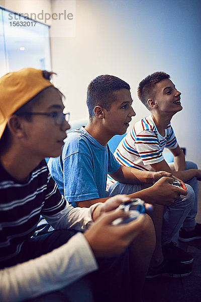 Teenager-Freunde spielen Videospiel in einer Spielhalle